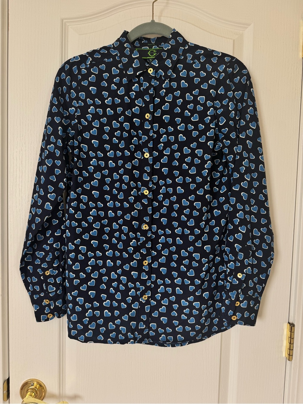 C. Wonder 100% silk blouse features a blue heart pattern and gold-toned buttons